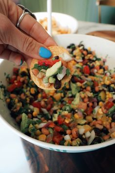 a person is holding up a tortilla filled with beans and veggies