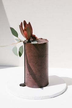 there is a small flower on top of a cake that has been decorated with leaves