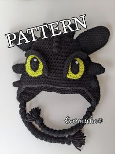 a crocheted dragon hat with yellow eyes