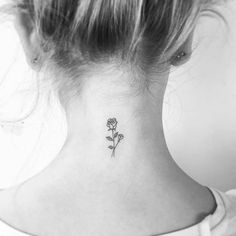 a woman's neck with a single rose tattoo on her left side ribcage