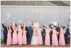 a group of people standing next to each other in front of a building with confetti