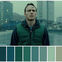 a man standing in front of a cityscape with lots of color swatches