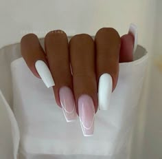 a woman's hand with white and pink manies on her nails, in front of a white shirt