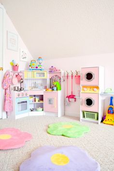 a child's play room with pink and green toys on the floor, white walls and carpet