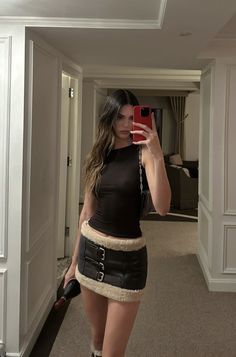 a woman is taking a selfie in the mirror while wearing a short skirt and boots