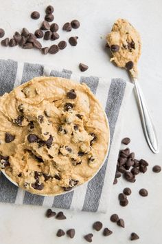 a bowl of cookie dough with chocolate chips on the side