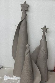 three cement christmas trees sitting next to each other