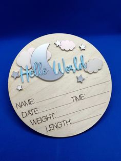 a wooden plaque with the words hello world written in blue and white stars on it