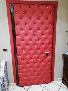 a red door with diamond studs on the front and side panels is shown in this room