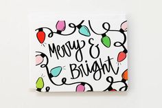 merry and bright greeting card with string lights on the front, in black ink against a white background