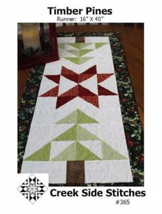 a quilted table runner with red and green stars on the top, along with an image of a christmas tree