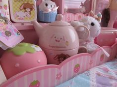 there is a pink tea set and other toys in the room with it's bed