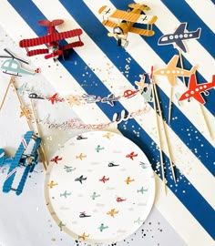 an assortment of paper airplanes on a blue and white striped background