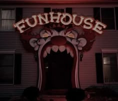 the neon sign for funhouse is lit up in front of a building with an open door