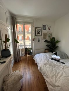 a bed room with a neatly made bed and wooden floors