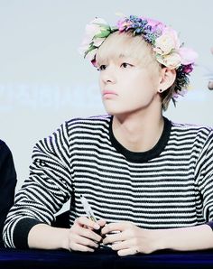 the young man is wearing a flower crown