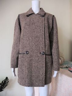 Stunning True Vintage coat from the 1980s. High quality wool fabric in a herringbone pattern, generous but structured cut, double-breasted style. Fake leather piping along the sleeve seams and the openings of the two front pockets. The piping along the sleeve seams gives the illusion of exaggerated shoulders - so 80s revival! The coat looks great in combination with a turtleneck jumper and a pair of jeans tucked into knee high slouch boots. Made in Sweden! ERA: 1980s BRAND: Fougstedts Malmö Swed Double-breasted Herringbone Winter Outerwear, Winter Herringbone Double-breasted Outerwear, Vintage Herringbone Outerwear For Fall, Vintage Herringbone Outerwear For Work, Vintage Pea Coat With Double Button Closure For Fall, Vintage Wool Outerwear With Herringbone Pattern, Vintage Brown Outerwear With Herringbone Pattern, Retro Wool Double-breasted Outerwear, Vintage Double-breasted Wool Coat