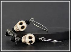 "Stone skull beads with jet black crystal eyes and black roses are paired in this unique pair of earrings. These are combined with silver metal for an elegant, spooky look. Everything comes together to create these fun new earrings. These earrings are one of a kind and artist made.  They have been created with high quality components and great attention to detail.  These earrings are 2 1/4\" long, and will arrive packaged beautifully for giving. Thank you for stopping by!" Handmade Black Skull Earrings, Nickel Free Black Skull Earrings, Adjustable Black Skull-shaped Earrings, Adjustable Black Skull Earrings, Black Skull Earrings For Parties, Halloween Black And White, Metal Roses, Skull Beads, Crystal Eyes