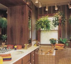 a bathroom with two sinks and plants in the bathtub, along with large windows