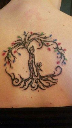 a woman's back with a tree tattoo on it