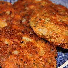 three crab cakes on a blue and white plate