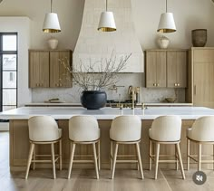 a large kitchen with wooden cabinets and white counter tops, along with four beige chairs