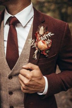 a man wearing a suit and tie with a boutonniere on his lapel