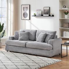 a living room filled with furniture and a rug on top of a hard wood floor