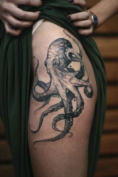 an octopus tattoo on the back of a woman's thigh