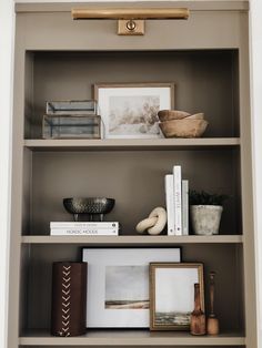 a book shelf with books and pictures on it