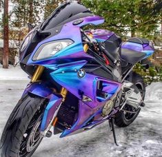 a purple and blue motorcycle parked in the snow