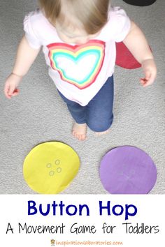 a toddler playing with buttons on the floor and in front of it is an infant's shirt that says, button hop a movement game for toddlers