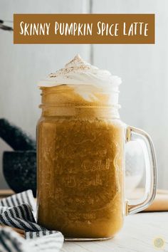 a pumpkin spice latte in a mason jar with whipped cream on top and text overlay that reads skinnyy pumpkin spice latte