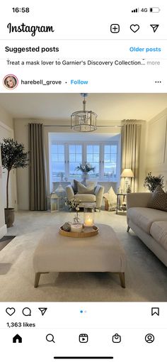 a living room filled with furniture and a chandelier hanging from the ceiling over a fire place