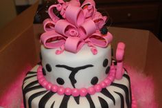 a zebra print cake with pink flowers on top