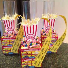 popcorn buckets filled with candy and confetti on top of a granite counter