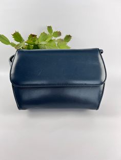 This  Simple Navy Blue Day Bag, a functional and stylish accessory for everyday use. This bag features a body of dark blue vinyl and a shoulder strap that makes it easy to carry. The spacious interior allows you to keep all your essentials organized and easily accessible. Measuring 8 1/2 inches by 6 1/2 inches, it is a perfect size for everyday use. The classic navy blue color and simple design make it a versatile option that can be paired with any outfit. In great condition for a vintage item. Modern Blue Shoulder Bag For Office, Modern Blue Box Bag For Travel, Modern Blue Shoulder Box Bag, Classic Blue Shoulder Box Bag, Blue Rectangular Shoulder Bag For Office, Classic Blue Box Bag For Travel, Modern Blue Box Bag For Everyday Use, Modern Blue Box Bag For Everyday, Blue Business Shoulder Bag With Detachable Handle