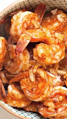 a bowl filled with cooked shrimp on top of a table