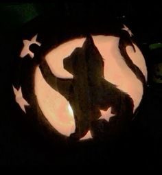 a carved pumpkin with a cat in the center and stars on it's side