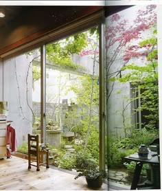 an open room with lots of windows and plants on the outside wall in front of it