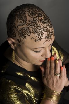 a woman with henna on her head eating a banana