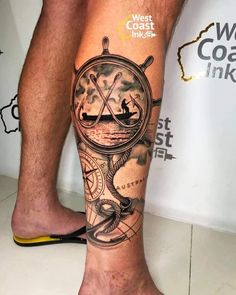 a man's leg with a compass tattoo on it and a boat in the water