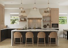 a kitchen with three stools in front of an island