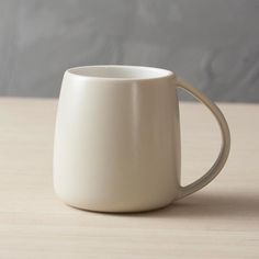 a white coffee cup sitting on top of a wooden table