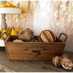 a wooden box filled with different types of bread and pastries on top of a table