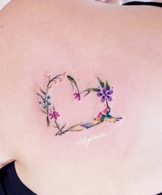 the back of a woman's stomach with flowers and leaves on it, which is shaped like a heart