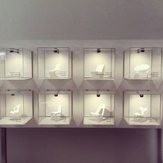 a display case filled with lots of white chairs on top of each other's sides