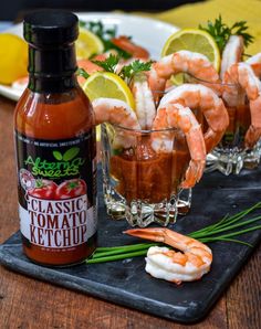 shrimp cocktails with garnishes and sauce on a slate serving tray, ready to be served