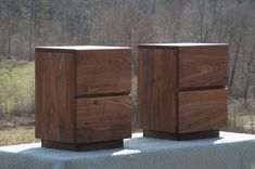 two wooden cubes sitting on top of a bed in the middle of a forest