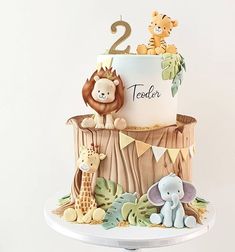 a two tiered jungle themed cake with animals on the top and second tier number